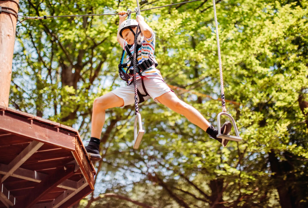 Person crossing ropes course in the forest.